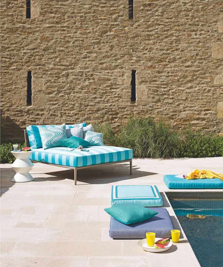 Brightly coloured pool loungers and cushions by the corner of a pool