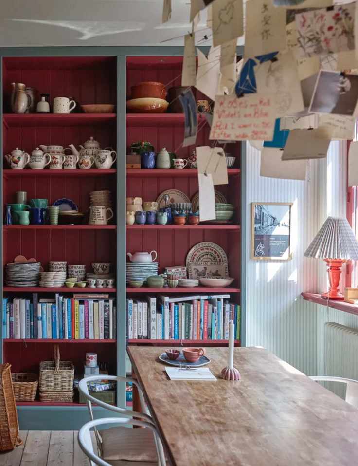 kitchen dining space with open shelving with red shiplap interior, books and crockery, dining table, Farrow & Ball : Asger Mortensen, Wester Agency