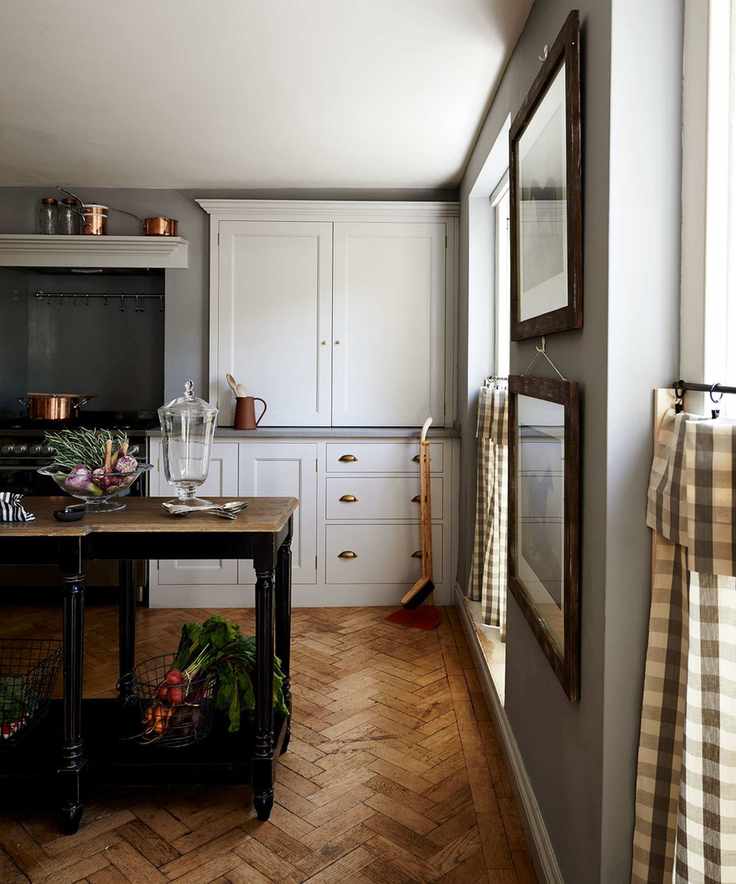 Grey kitchen walls with parquet flooring and gingham blinds.