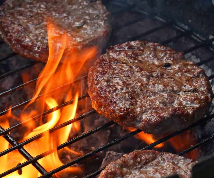 Grilling beef burgers on a charcoal grill