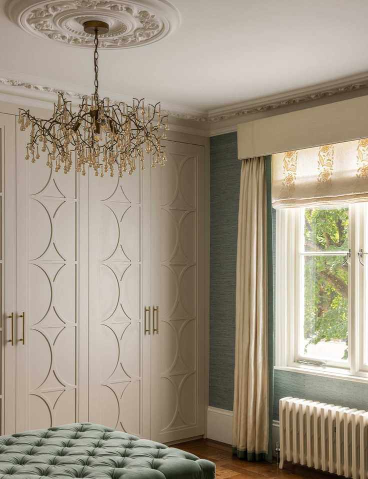 Stylish dressing room featuring a crystal chandelier and layered window treatments.