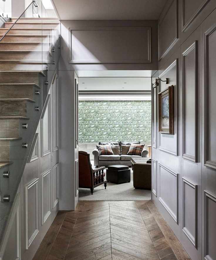 An entryway with wooden stairs and a living room beyond.