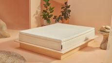 An Earthfoam mattress on a bed against peach walls.
