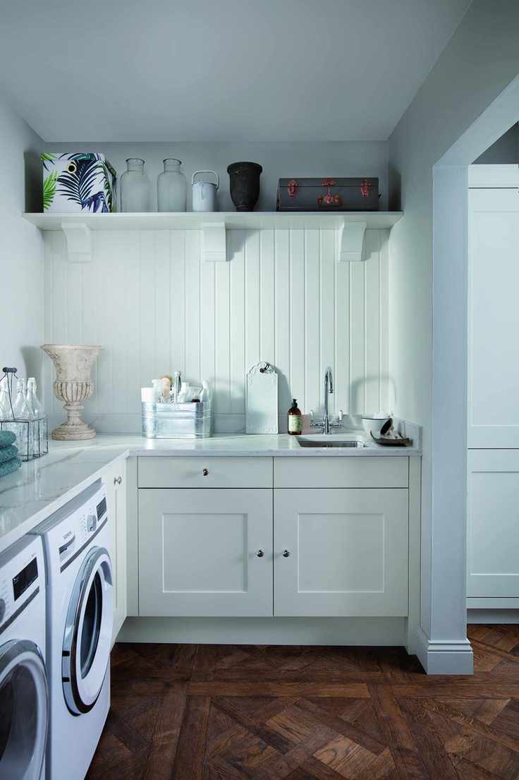 An open plan utility room leading into a kitchen.