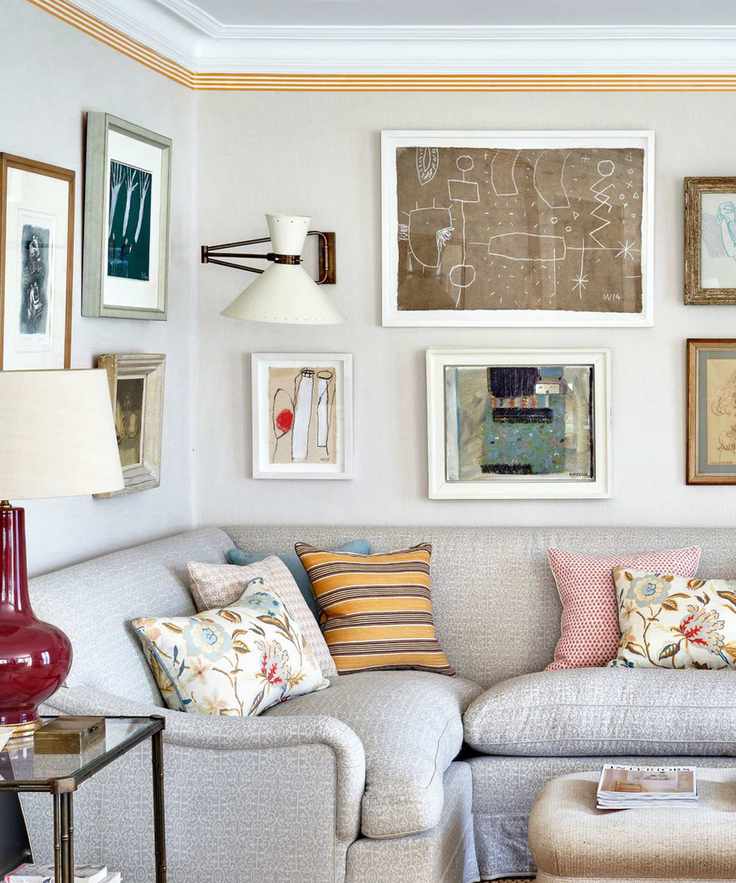 corner couch with patterned throw pillow and a gallery wall