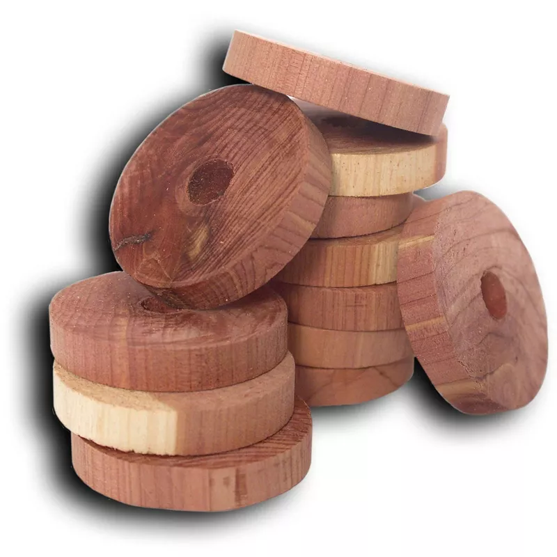 A messy stack of round cedar rings with small holes drilled in the center.