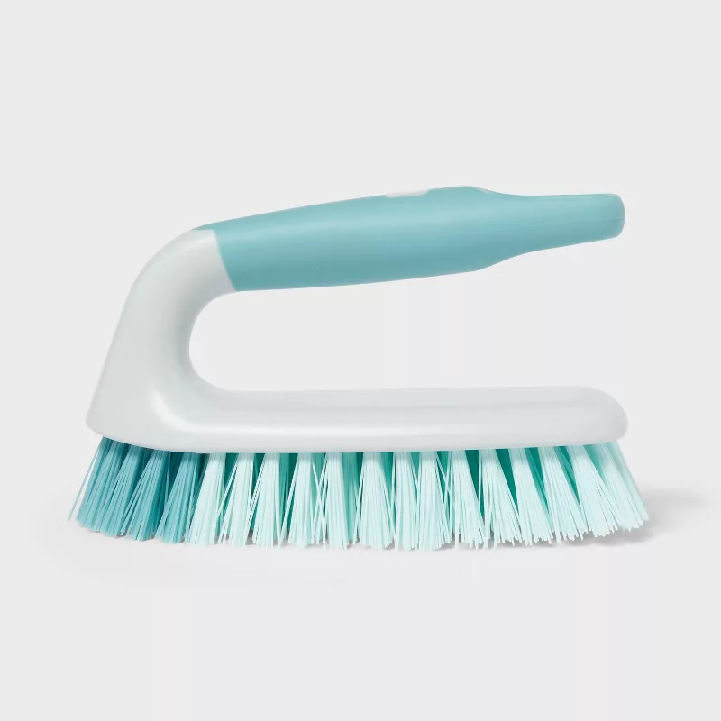 Small handheld scrubbing brush in pale blue and white