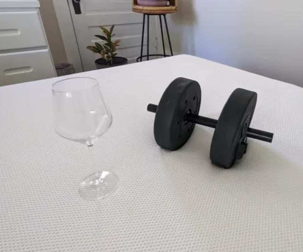 Wine glass and dumbbell on the mattress