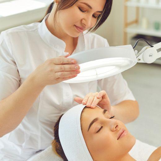 Dermatologist examining woman's skin during skin care consultation