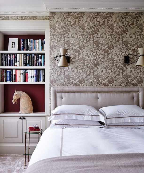Alcove bookshelves and a gray upholstered bed showing small bedroom storage solutions.
