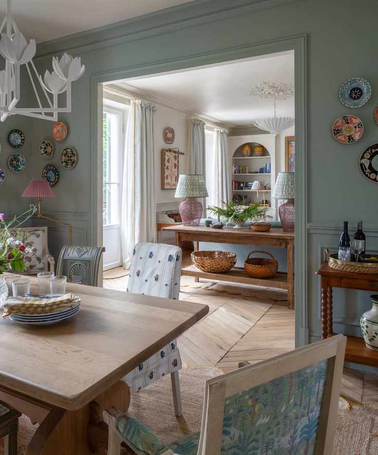blue painted dining room filled with pretty vintage cottage style pieces with an open plan view through to the kitchen