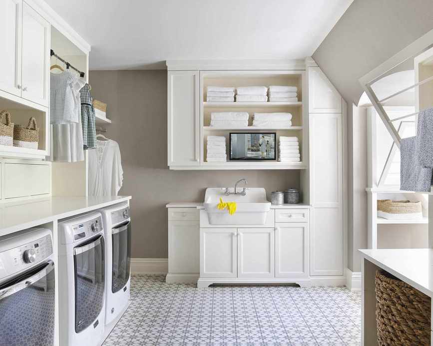 Laundry room with built-in units featuring a clothes rail for convenience.