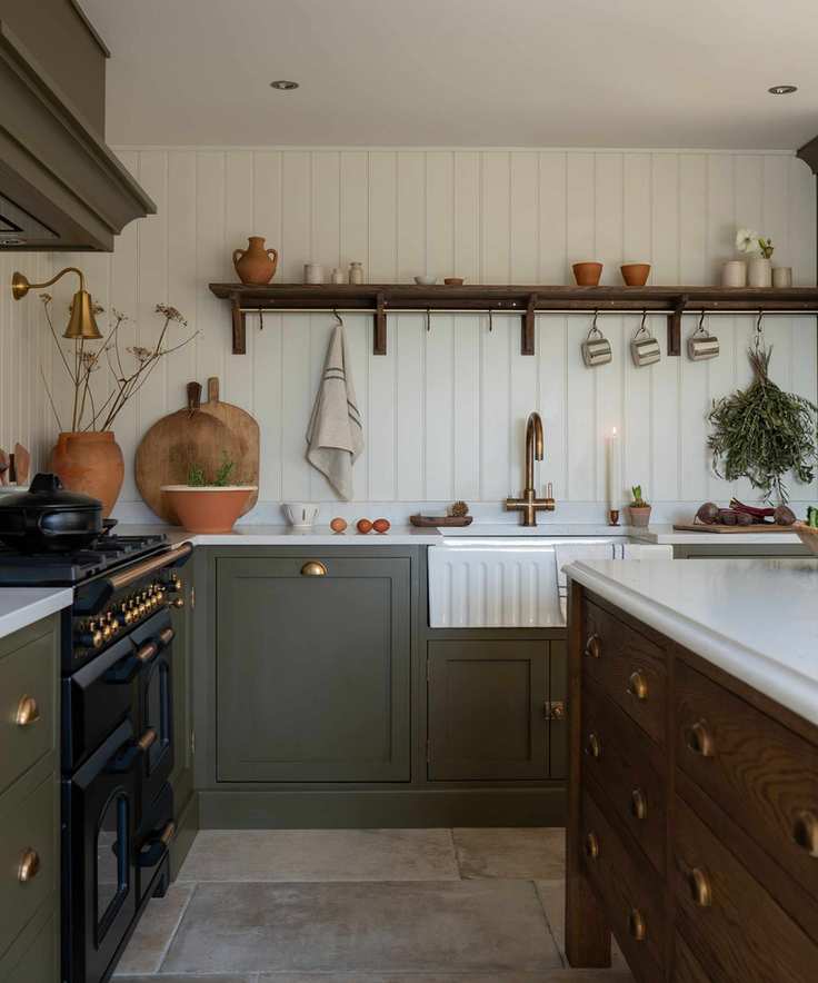 A kitchen with green cabinets and white paneled walls