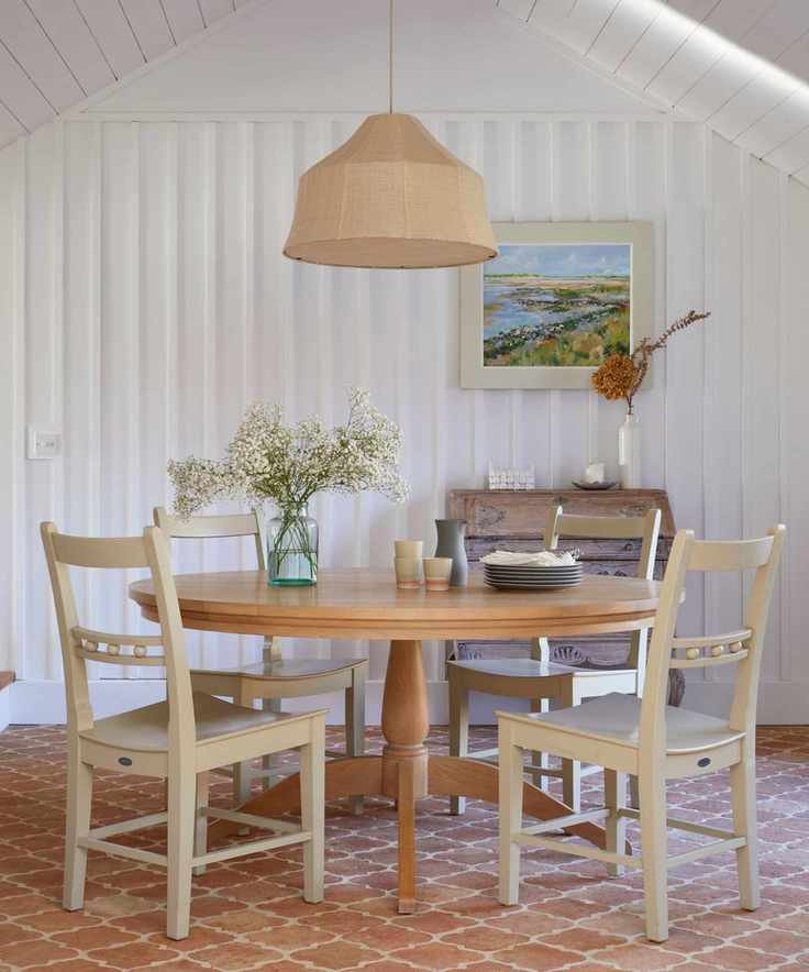 modern farmhouse dining room with white shiplap walls and terracotta floors