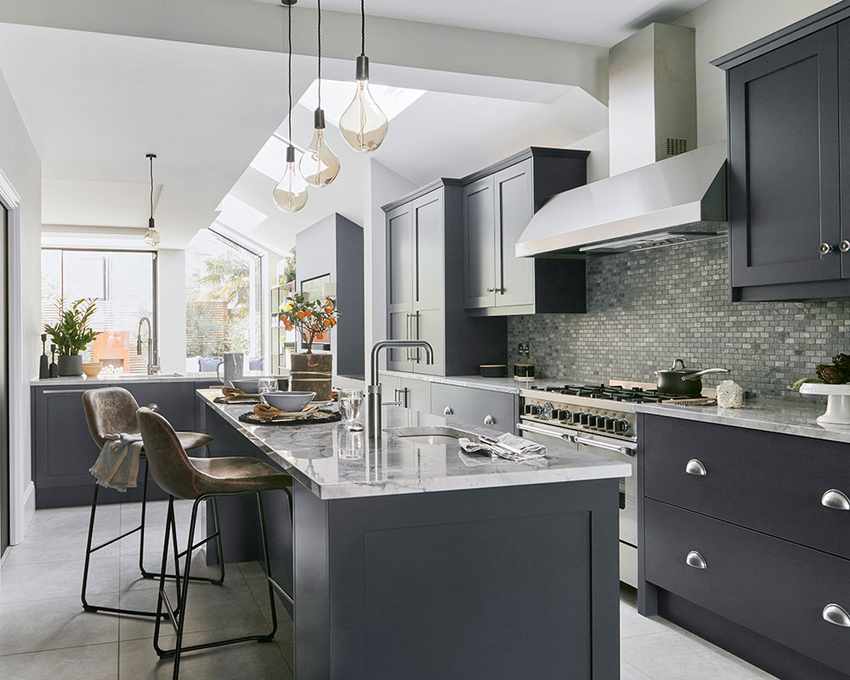 A kitchen extension featuring a large island with brown leather stools