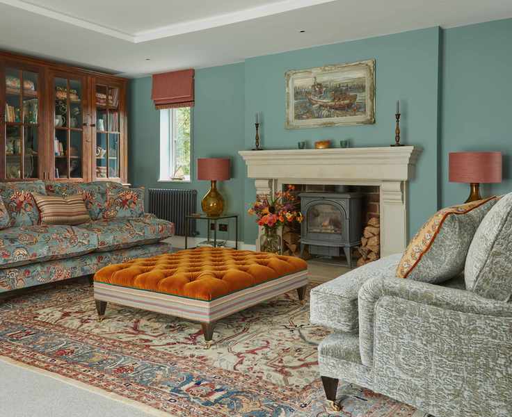 orange ottoman in a living room with walls painted light teal