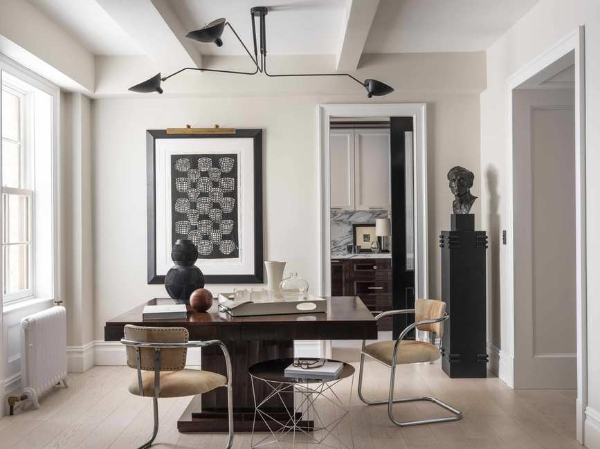 dining room with white walls, a chunky, glossy wood dining table, metal dining chairs, a large black piece of artwork, and a statue