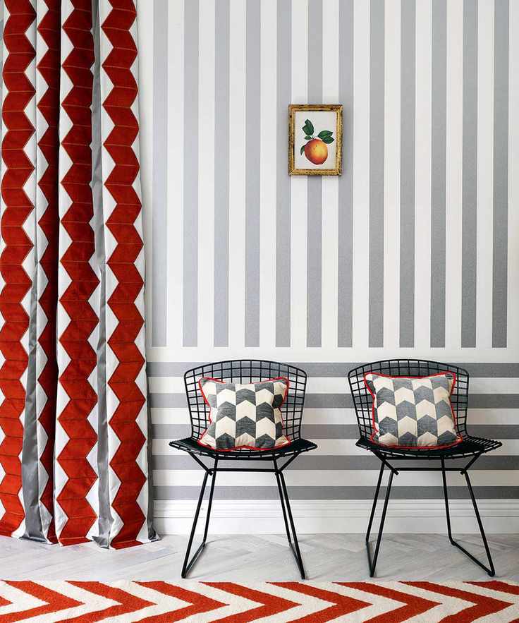 Side chairs with geometric patterned pillows, curtain with geometric strips and chevron rug