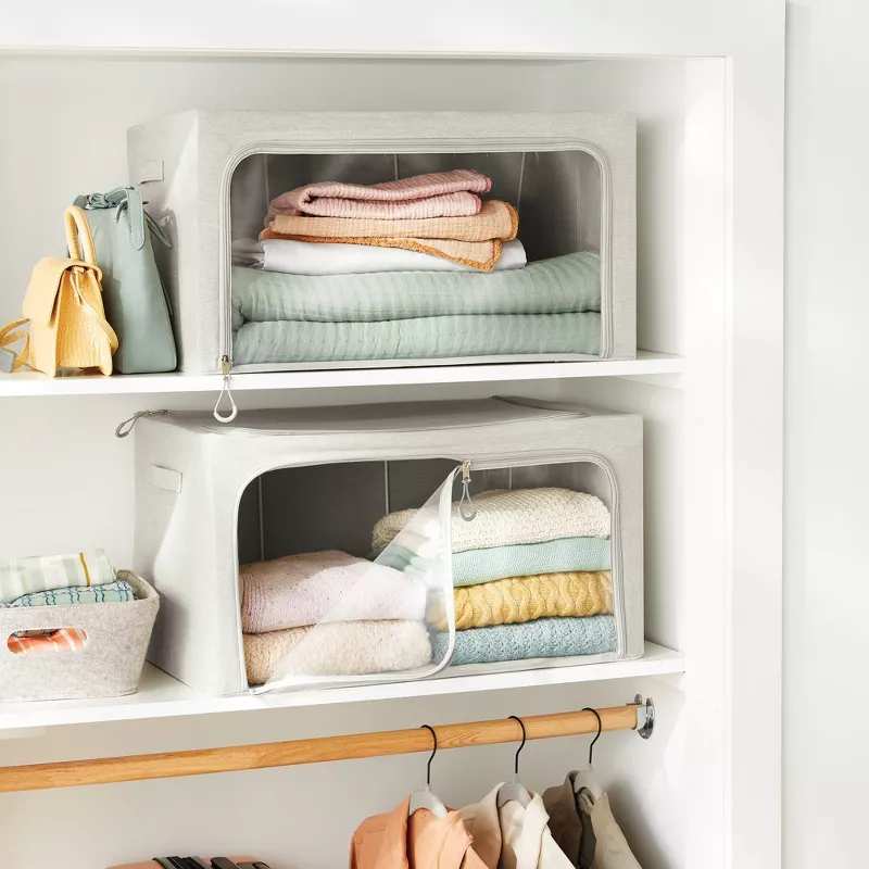 Two clear front storage boxes on closet shelves.