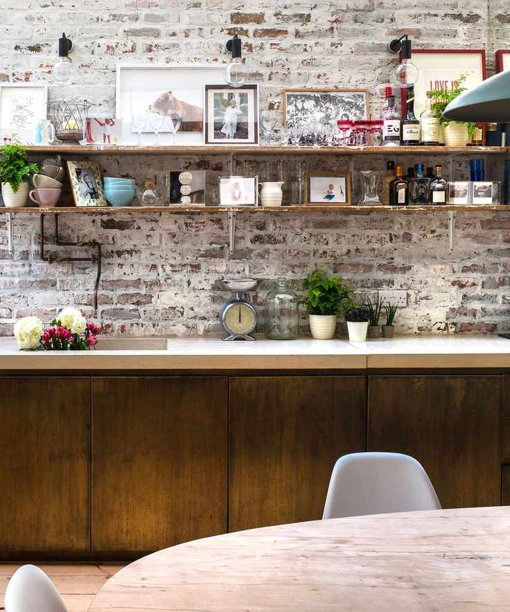Kitchen wall lighting above wooden open shelves on an exposed brick wall.