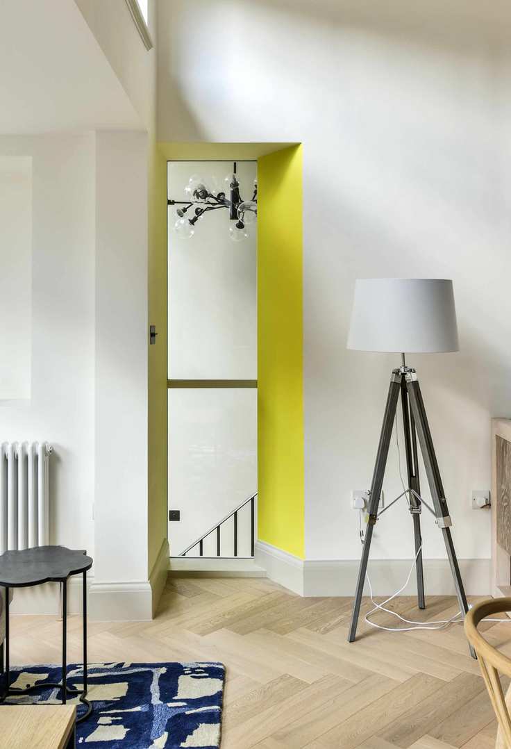 White walls, neon yellow archway, wooden floor
