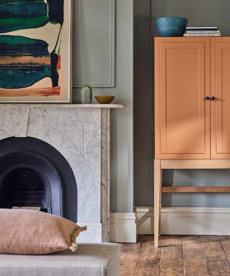 warm vs cool colors, living room with grey walls, coral cabinet, artwork, fire place, wooden floorboards