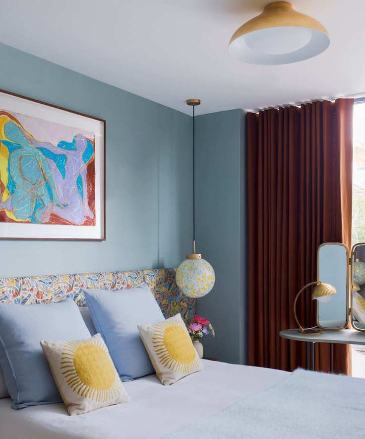 blue bedroom with pops of yellow and retro inspired decor