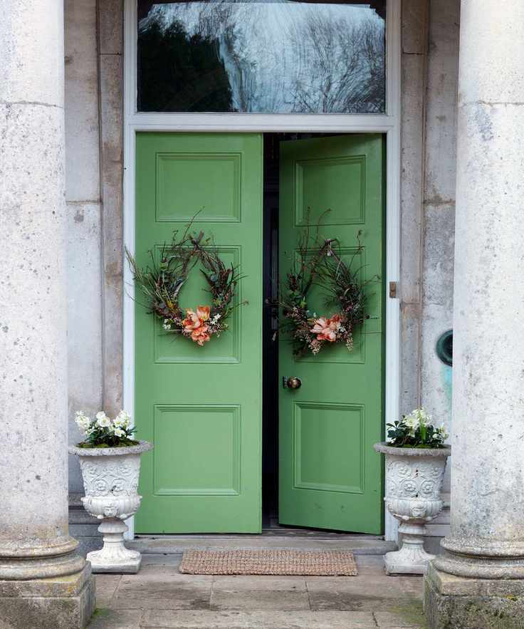 Double doors, painted green with an Easter wreath on each side