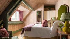 A cozy, traditional bedroom with pink and green decor.