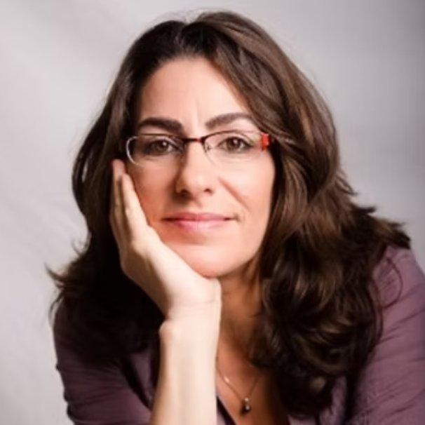 a headshot photo of professional organizer Keren Gava: a lady with long dark brown hair, red and black glasses, and a purple lightweight sweater