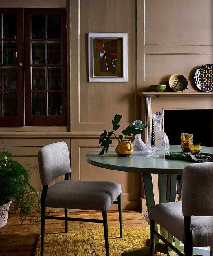 round green dining table, upholstered chairs and yellow rug