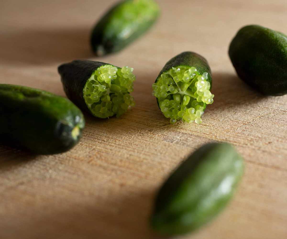 The fruits of a finger lime, with one cut open to reveal the unique pale seeds