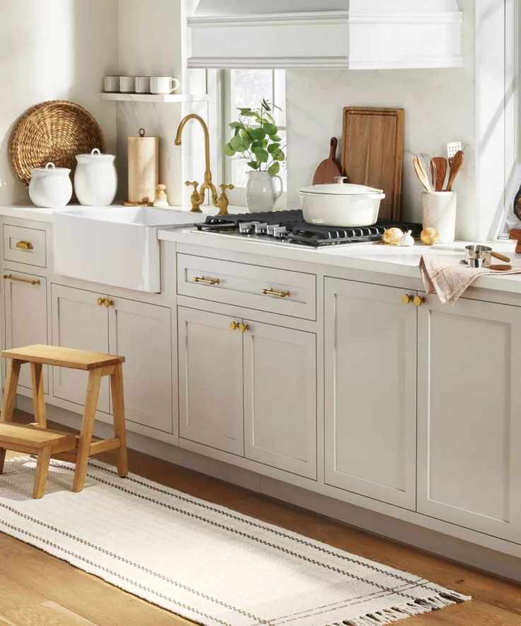 White shaker kitchen with brass hardware and wooden decor