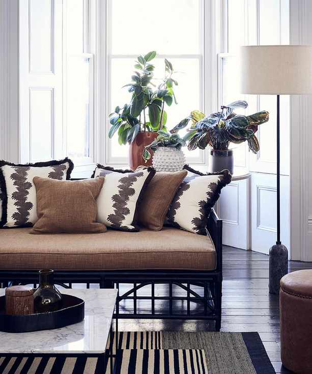 Global traveller style living room pictures showing a brown sofa with coordinating cushions and a monochrome rug.