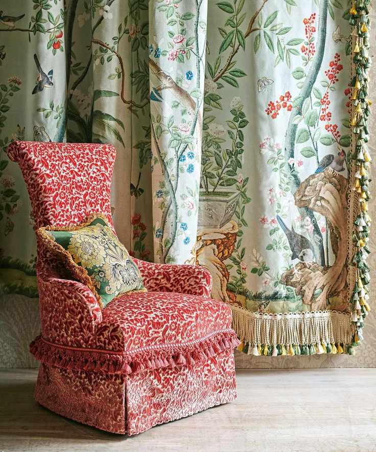 Red patterned chair with fringe, floral curtains with fringe