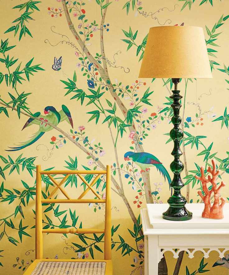 Yellow hallway with tropical wallpaper featuring birds and leaves, wooden console table, yellow chair