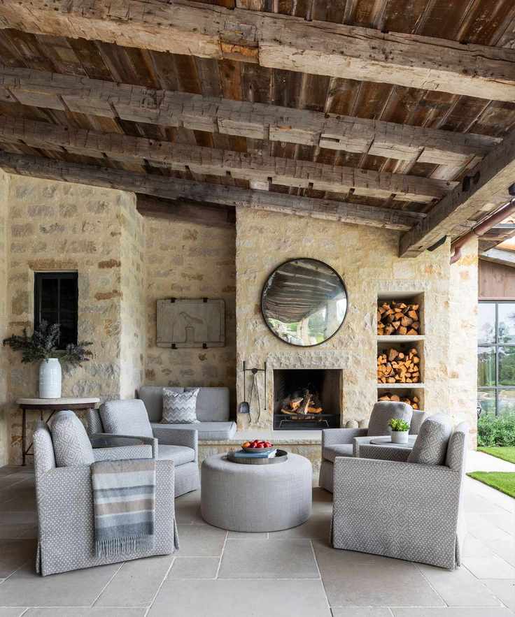 Outdoor porch area featuring a rustic reclaimed wood ceiling and light stone wall with cozy furniture