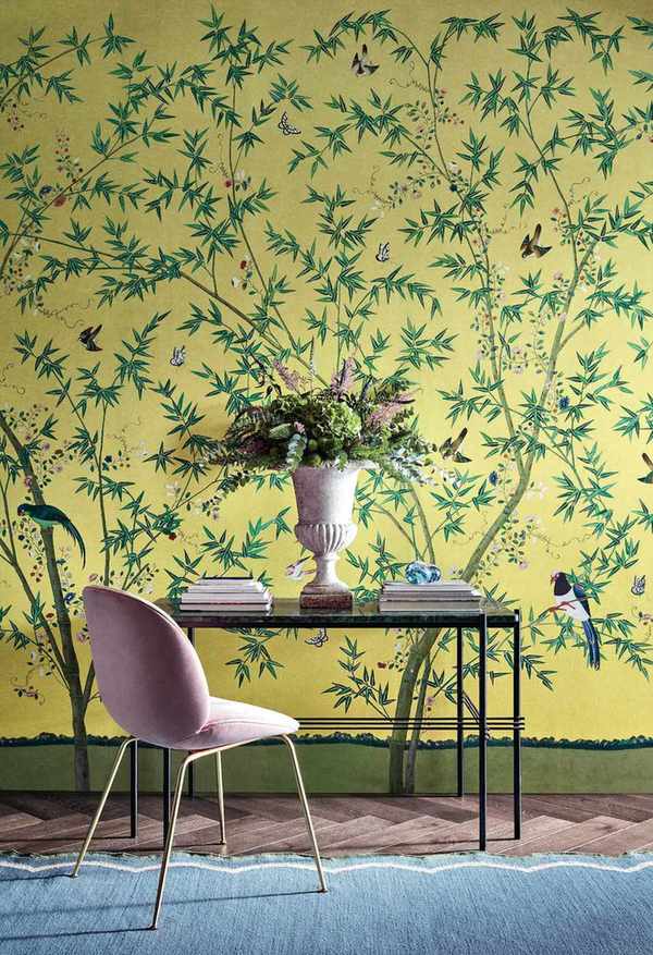 console table with pink chair, blue rug and yellow wall mural floral bird wallpaper