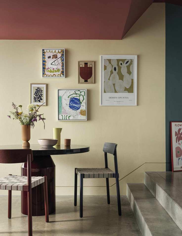 Dining room painted in Pale Gold by Crown with a gallery wall and red ceiling