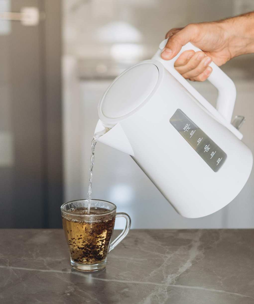 A cheap plastic kettle pouring tea