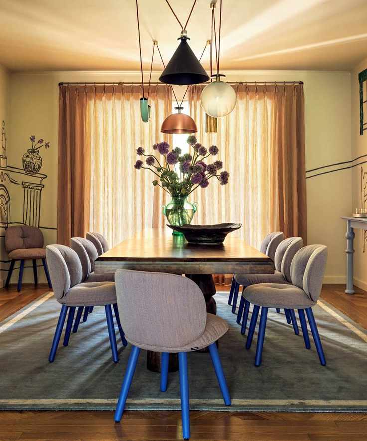 Dining room with painted mural, large wooden table and grey and electric blue dining chairs