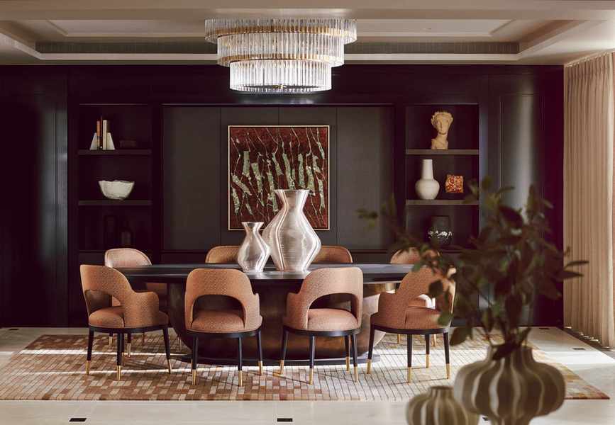 A rich and dramatic dining area in Chelsea Barracks with round table and chandelier