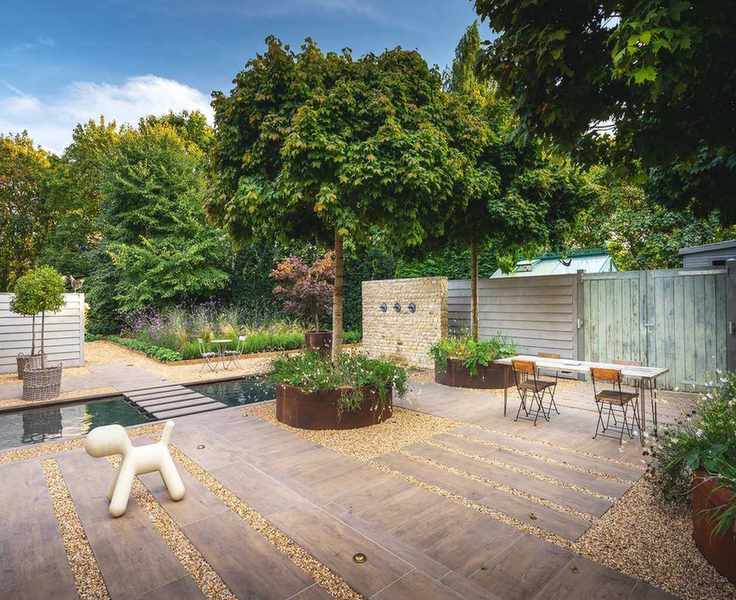Garden with gravel and paving and large corten steel planters