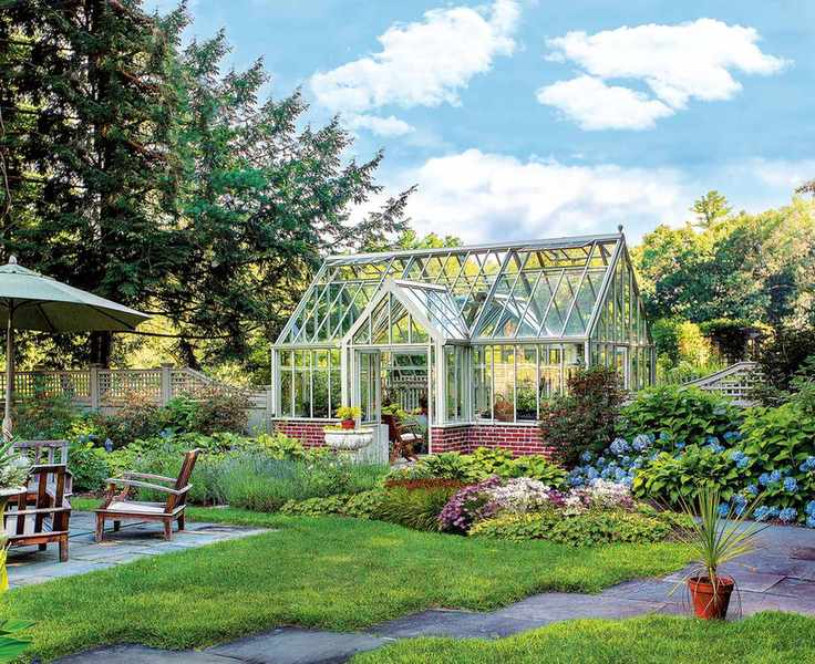 A spacious greenhouse surrounded by greenery and flowers