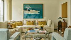 a neutral london living room with a large cream sectional and a blue and yellow color palette
