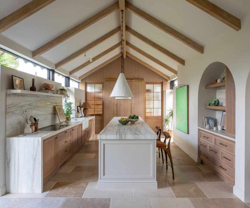 A midimalist kitchen with wooden cabinetry and marble surfaces