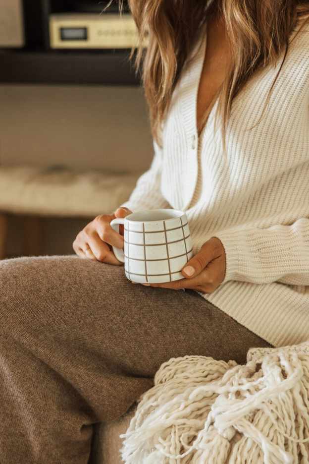 Woman enjoying a cozy fall mug.