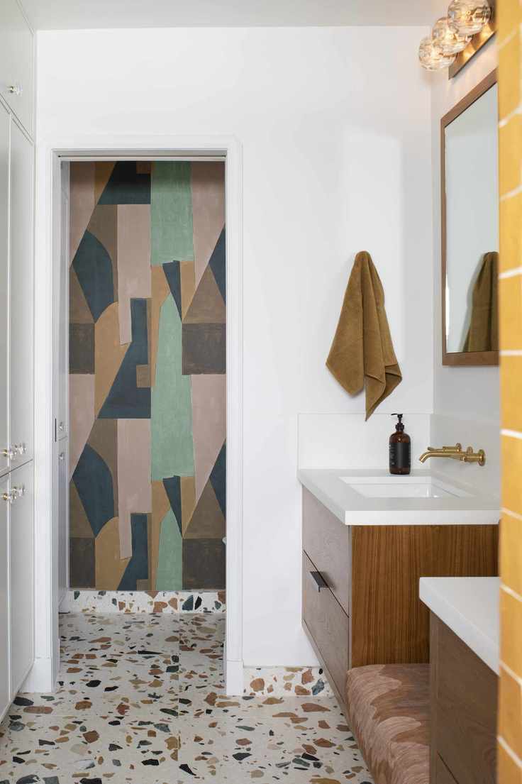 White bathroom with terrazzo floor tiles and wall mural