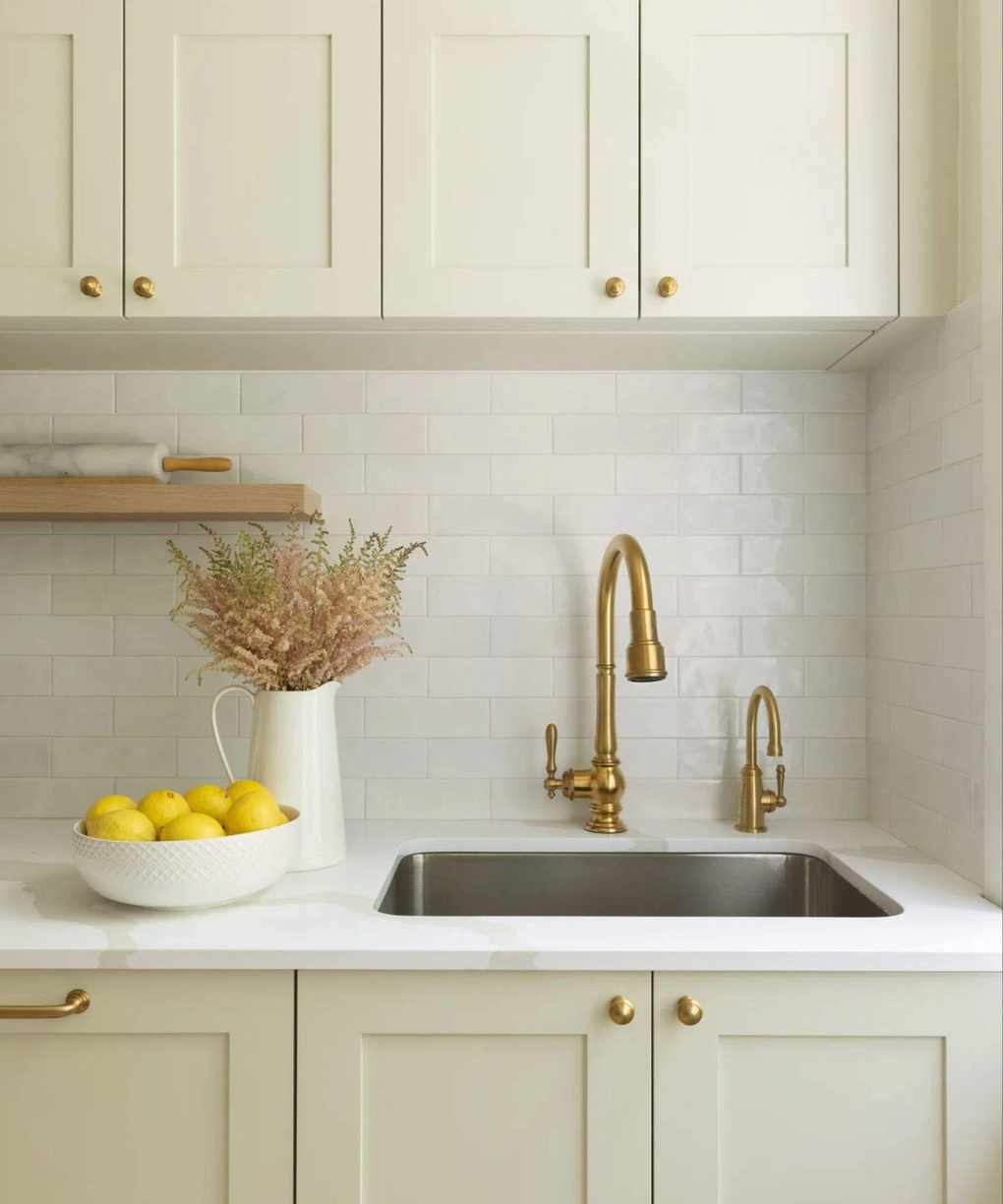 neutral kitchen with subway tiles and a brass faucet