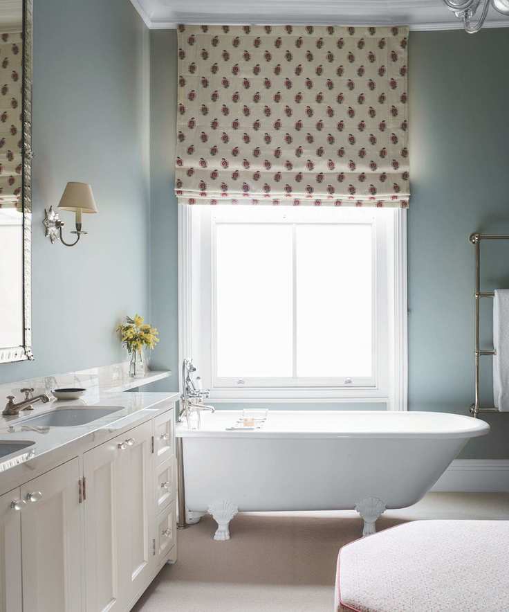 Elegant bathroom featuring a white clawfoot tub and large mirror.